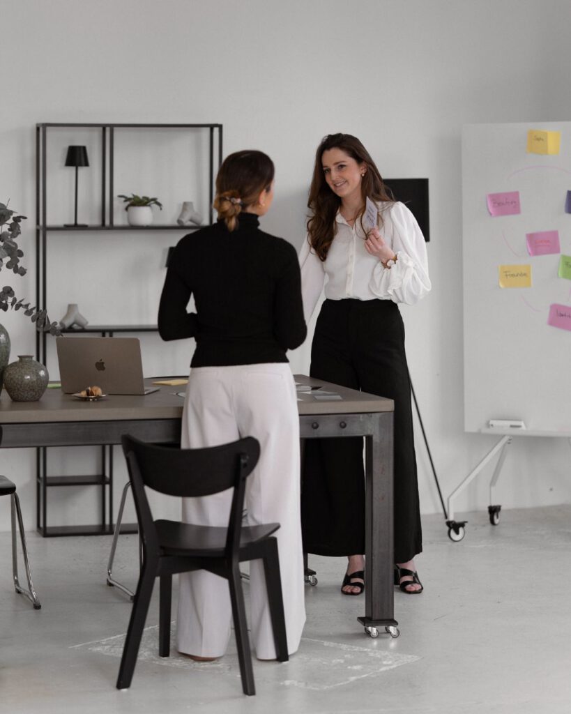 Zwei Frauen in Coaching-Situation vor einem Whiteboard.